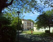 11 Un ensemble de plusieurs bâtiments, avec pas mal de verdure.